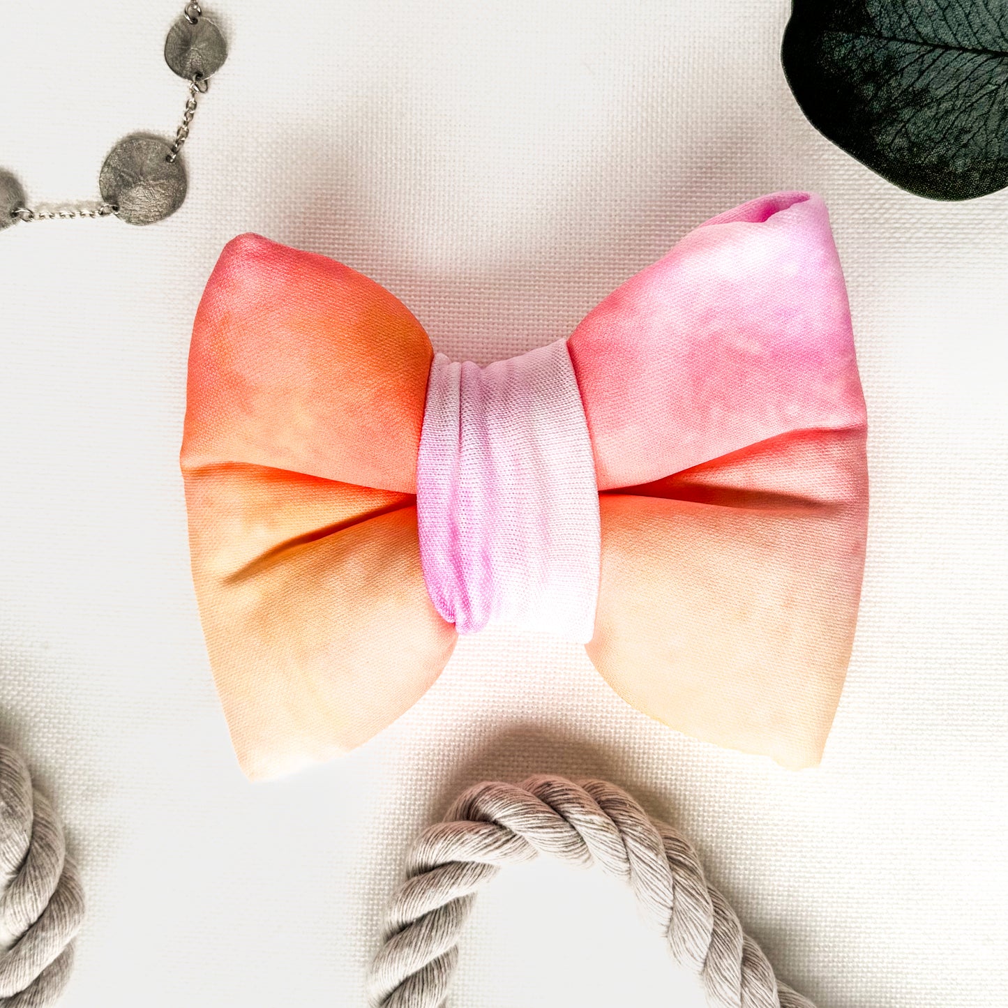 A pink and yellow tie dye classic dog bowtie.