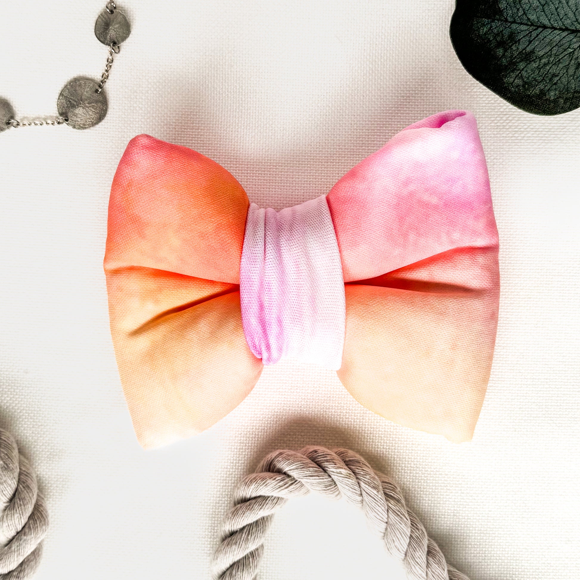 A pink and yellow tie dye classic dog bowtie.