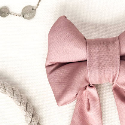 Close up view of a pink dog sailor bow.