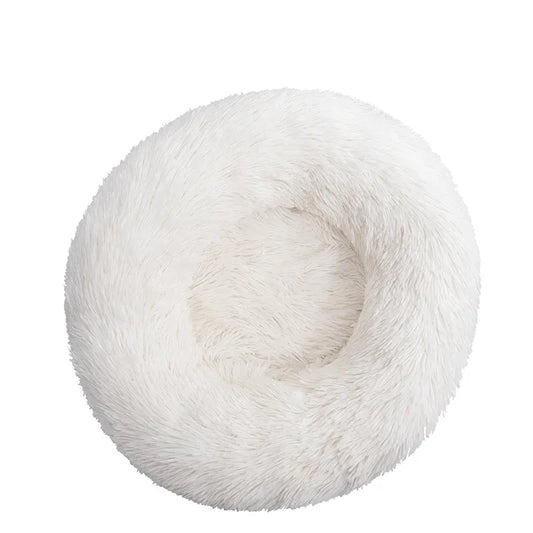 A white plush dog bed shaped like a donut, offering a comfortable and secure space for small dogs to curl up and relax.
