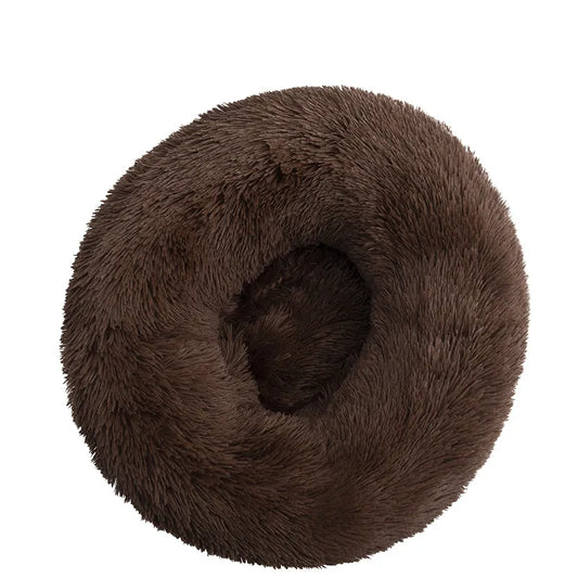 A brown plush dog bed shaped like a donut, offering a comfortable and secure space for small dogs to curl up and relax.