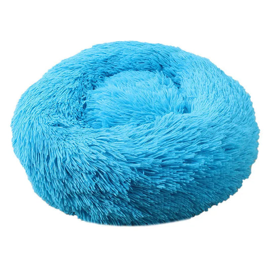 A blue plush dog bed shaped like a donut, offering a comfortable and secure space for small dogs to curl up and relax.