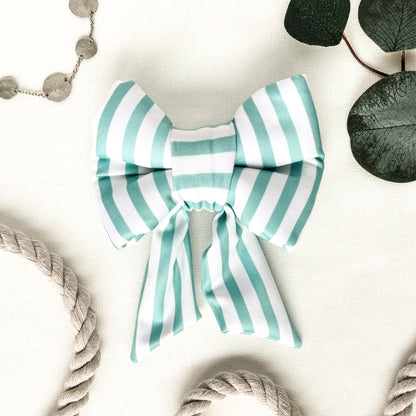 A turquoise and white striped dog sailor bow.