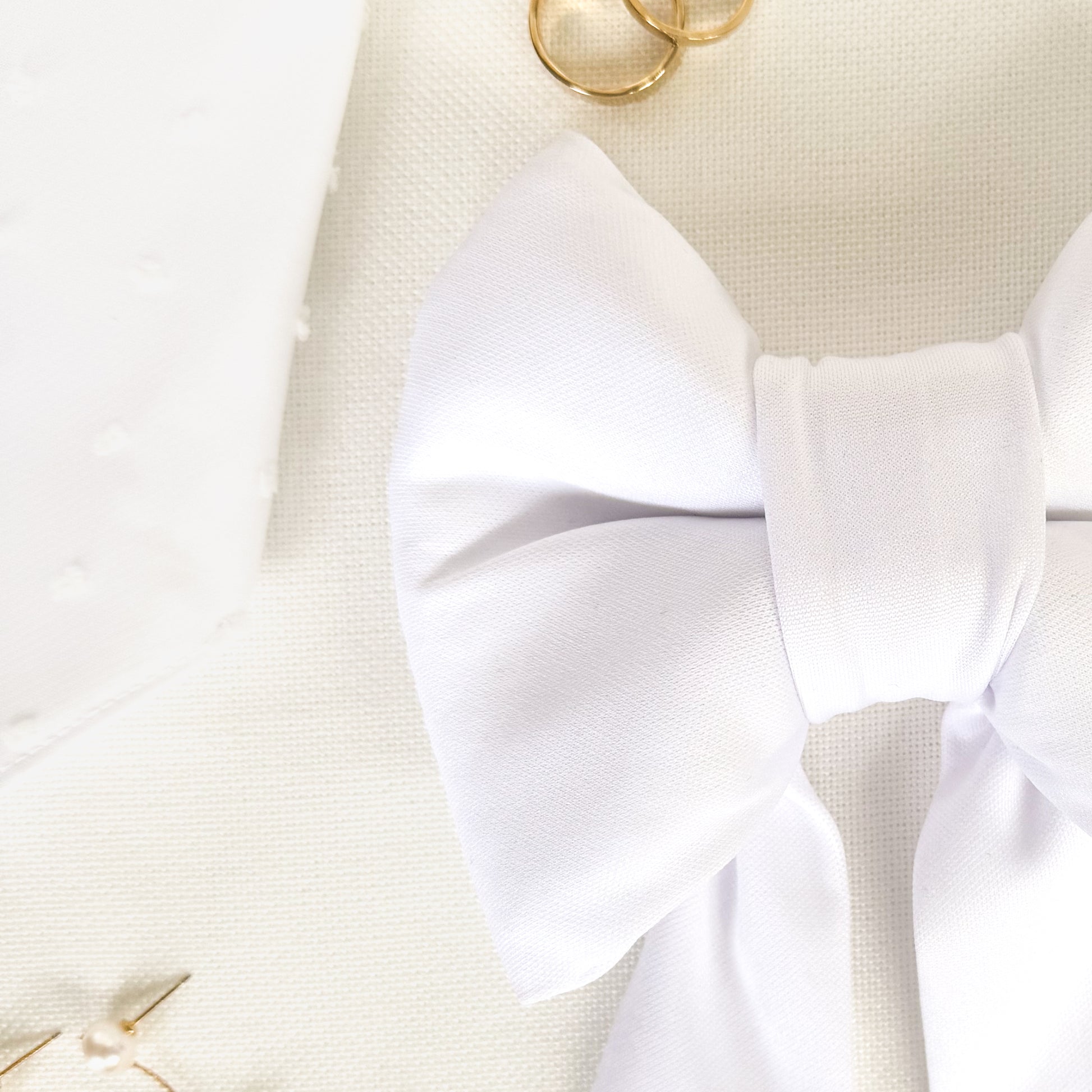 Close up view of a white bridal dog sailor bow.