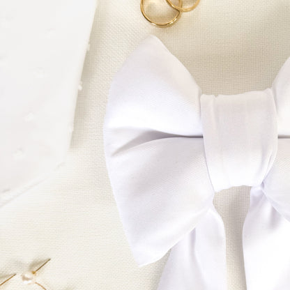 Close up view of a white bridal dog sailor bow.